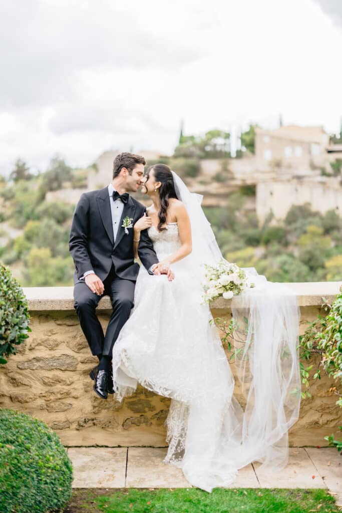 Un couple élégant partage un moment romantique dans un cadre pittoresque, symbolisant le luxe d'un mariage en Provence. Avec des paysages de vignobles en arrière-plan, cette célébration sur mesure incarne l'essence d'un événement unique. By Mademoiselle C crée des cérémonies grandioses dans des lieux d'exception, parfaits pour un rêve de mariage inoubliable.