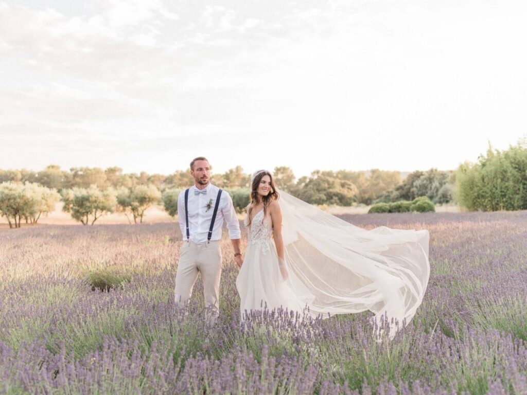 Un couple élégant se tient main dans la main au milieu d'un champ de lavande, incarnant la magie d'un mariage romantique en Provence. Cette scène captivante illustre parfaitement l'expertise de By Mademoiselle C en matière de planification de mariages de luxe. Avec des paysages enchanteurs et une atmosphère sophistiquée, chaque détail contribue à créer une célébration unique. Que ce soit pour une cérémonie grandiose ou un événement sur mesure, ce cadre idyllique