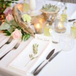 Une table élégamment dressée pour un mariage de luxe en Provence, avec des détails raffinés tels que des roses délicates, des bougies scintillantes et des éléments naturels. Ce cadre romantique met en valeur l'expertise de By Mademoiselle C dans l'organisation de célébrations sur mesure, parfaites pour un grand événement dans un domaine privé. Chaque détail, des couverts en argent aux marques-places personnalisés, souligne l'engagement à créer des mariages exceptionnels