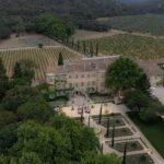 Une vue aérienne d'un domaine privé en Provence, où se déroule une célébration de mariage romantique et luxueuse. Entouré de vignobles verdoyants et de jardins élégants, cet emplacement exceptionnel est parfait pour une cérémonie grandiose. Le cadre sophistiqué met en valeur l'organisation sur mesure d'un mariage de rêve, offrant une atmosphère intime et raffinée pour un événement unique. Le mariage, orchestré par By Mademoiselle C, incarne l'essence