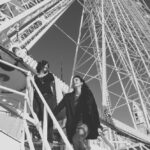 Une scène romantique et élégante capturant un couple souriant s'élevant vers la grande roue, symbolisant une célébration unique. En tant que wedding planner de luxe en Provence, Côte d'Azur et Corse, By Mademoiselle C crée des mariages sur mesure dans des lieux exceptionnels. Cette image évoque la magie d'un événement grandiose, parfait pour un mariage de rêve, entouré par l'atmosphère vivante et sophistiquée du sud de la France