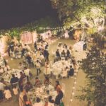 Un élégant dîner de mariage en plein air, organisé par By Mademoiselle C, dans un cadre romantique et sophistiqué. Les invités profitent d'une soirée magique sous les lumières scintillantes, entourés par la beauté d'un domaine privé en Provence. Cette célébration sur mesure incarne le luxe et l'exclusivité d'un mariage de rêve, avec des tables délicatement décorées pour une expérience inoubliable. C'est un événement unique qui transforme chaque instant en un