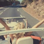 Un couple rayonnant en voiture décapotable, célébrant leur rêve de mariage dans les paysages pittoresques de Provence. Avec les bras levés vers le ciel, ils incarnent l'esprit d'une cérémonie grandiose et romantique, parfaitement orchestrée par By Mademoiselle C. Cette image évoque une célébration unique, mêlant luxe et élégance, tout en mettant en avant l'atmosphère sophistiquée des routes ensoleillées menant vers des domaines privés et