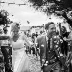 Célébration romantique d'un mariage de luxe en Provence, avec un couple rayonnant sous une pluie de pétales, entouré d'amis et de famille. Ce moment capturé illustre l'expertise de By Mademoiselle C dans l'organisation de cérémonies sur mesure dans des lieux exceptionnels. L'atmosphère élégante et sophistiquée de cet événement fait de chaque mariage un moment unique, parfait pour une grande célébration au cœur de la Côte d'