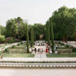 Un cadre romantique et élégant pour un mariage de luxe à Provence, Côte d'Azur et Corse. Ce jardin exquis, avec ses allées bordées de cyprès et ses parterres de fleurs soigneusement entretenus, est l'endroit idéal pour une cérémonie grandiose. La disposition sur mesure des chaises témoigne de l'organisation bespoke de 'By Mademoiselle C', créant une atmosphère sophistiquée pour une célébration unique. Ce lieu exceptionnel, entouré de