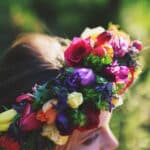 Une couronne florale colorée ornant une mariée dans un cadre romantique, illustrant l'expertise de By Mademoiselle C pour des mariages de luxe en Provence, Côte d'Azur et Corse. Ce moment évoque une célébration grandiose, où chaque détail est soigneusement organisé pour créer un événement unique et sur mesure. Les fleurs vibrantes symbolisent l'élégance et la sophistication d'un mariage sur un domaine privé, offrant une atmosphère féerique