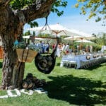 Un mariage luxueux dans un cadre idyllique au cœur d'un jardin verdoyant en Provence, Côte d'Azur et Corse. Cette célébration romantique met en avant une organisation sur mesure, avec une table élégamment dressée sous des parasols, entourée d'invités décontractés. Les détails raffinés, comme les chapeaux posés au sol et les fleurs délicates, créent une atmosphère sophistiquée pour un événement unique. By Mademoiselle C