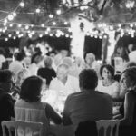 Dîner élégant sous les lumières scintillantes, illustrant une célébration de mariage romantique dans un domaine privé en Provence. Cette soirée de luxe, organisée par By Mademoiselle C, incarne l'essence d'un mariage sur mesure, offrant une ambiance sophistiquée pour un grand événement. Les invités, entourés de verdure et de lumière douce, vivent une expérience inoubliable dans un cadre exceptionnel, parfait pour une cérémonie grandiose ou un rêve de mariage.