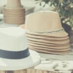 Chapeaux élégants disposés sur une table en bois, évoquant l'ambiance romantique et sophistiquée d'un mariage sur mesure en Provence, Côte d'Azur et Corse. Parfaits pour une cérémonie grandiose ou une célébration unique, ces accessoires ajoutent une touche de luxe à un événement sur un domaine privé ou dans un cadre exceptionnel. Idéal pour un mariage de rêve, chaque détail est soigneusement organisé pour créer une expérience inoubliable.