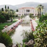 Un cadre romantique et élégant pour un mariage de luxe à Provence, Côte d'Azur et Corse, mettant en valeur un domaine privé exceptionnel. Ce jardin somptueux, avec ses fontaines et ses fleurs colorées, offre l'environnement parfait pour une célébration grandiose. La beauté naturelle des montagnes en arrière-plan crée une ambiance idéale pour un événement sur mesure, garantissant une expérience inoubliable pour un mariage de rêve. 'By Mademoiselle C' excelle dans l'organisation