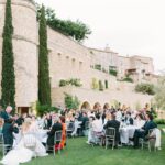 Un élégant dîner en plein air dans un domaine privé en Provence, où des invités raffinés célèbrent un mariage de luxe. La scène dégage une atmosphère romantique, entourée de paysages pittoresques, typiques de la Côte d'Azur. Cette célébration sur mesure, orchestrée par By Mademoiselle C, met en valeur des tables magnifiquement dressées et une décoration sophistiquée, idéale pour un grand événement. Ce cadre unique et enchanteur est parfait