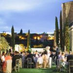 Réception élégante en plein air, organisée par By Mademoiselle C, mettant en avant un mariage de luxe dans un cadre romantique en Provence. Les invités profitent d'un grand banquet sous un ciel étoilé, entourés de cypress et d'une vue imprenable sur les collines. Ce moment unique incarne l'essence d'une célébration grandiose, avec une attention particulière portée à chaque détail pour créer un événement sur mesure dans un domaine privé exceptionnel. L'atmos