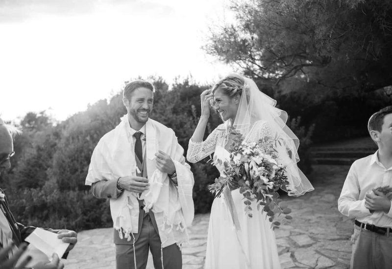 Une scène romantique d'un couple heureux lors de leur cérémonie de mariage en Provence, capturant l'essence d'une célébration grandiose. Ce moment, empreint d'élégance, illustre le savoir-faire de By Mademoiselle C en tant que planificateur de mariage de luxe dans des lieux exceptionnels. Les invités, entourés par la beauté naturelle des montagnes, témoignent d'un événement sur mesure, reflétant une organisation impeccable pour une journée inoubliable.