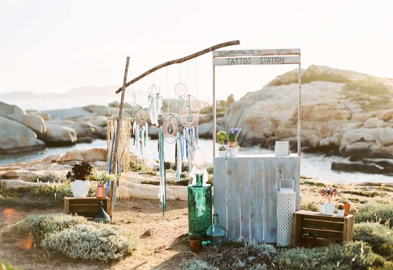 Un coin élégant et romantique pour un mariage de luxe en Corse, mettant en avant une station de tatouage artisanale, idéale pour une célébration unique. Avec des vues imprenables sur la mer, cet espace est parfait pour une cérémonie sur mesure, entouré de paysages naturels. 'By Mademoiselle C' crée des événements mémorables dans des lieux exceptionnels, garantissant une expérience inoubliable pour un grand jour. Offrez-vous le mariage de vos rêves, all