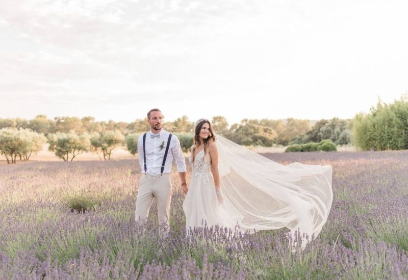 Un couple élégant se tient main dans la main au milieu d'un champ de lavande, incarnant la magie d'un mariage romantique en Provence. Cette scène captivante illustre parfaitement l'expertise de By Mademoiselle C en matière de planification de mariages de luxe. Avec des paysages enchanteurs et une atmosphère sophistiquée, chaque détail contribue à créer une célébration unique. Que ce soit pour une cérémonie grandiose ou un événement sur mesure, ce cadre idyllique