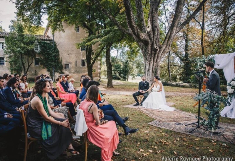 Cérémonie romantique en plein air, organisée par By Mademoiselle C, dans un cadre idyllique de Provence. Ce mariage sur mesure, niché dans un domaine privé, offre une atmosphère élégante et sophistiquée. Les invités, habillés avec goût, assistent à cet événement grandiose sous un majestueux arbre, tandis que le couple rayonne de bonheur. Un moment inoubliable pour une célébration unique, mettant en avant l'expertise de By M