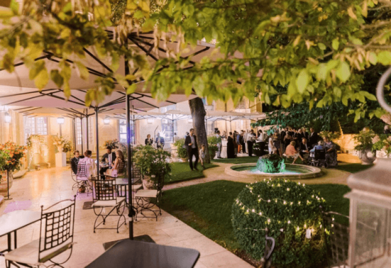 Une élégante célébration de mariage en plein air dans un jardin romantique, mettant en avant le savoir-faire de 'By Mademoiselle C' en tant que wedding planner de luxe en Provence, Côte d'Azur et Corse. L'atmosphère sophistiquée, agrémentée de lumières douces et de décorations délicates, crée un cadre idéal pour un grand événement. Ce mariage sur mesure souligne l'importance de lieux exceptionnels, tels que ce domaine privé, pour