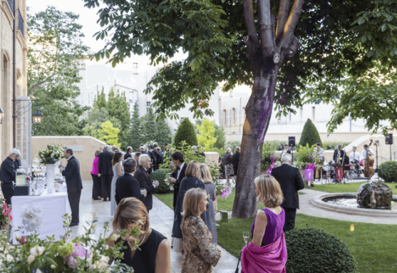 Mariage élégant dans un jardin raffiné, mettant en avant l'expertise de By Mademoiselle C en tant que Wedding Planner en Provence, Côte d'Azur & Corsica. Cette célébration grandiose, entourée de plantes luxuriantes et de fleurs colorées, évoque une ambiance romantique et sophistiquée. Les invités, habillés avec soin, profitent d'un événement sur mesure dans un domaine privé exceptionnel, créant une expérience inoubliable pour un mariage de luxe