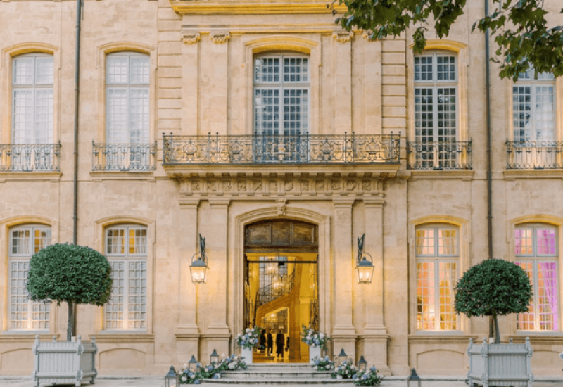 Superbe façade d'un hôtel de luxe, emblématique de la Provence, Côte d'Azur et Corse, idéale pour un mariage romantique. Cette propriété élégante, entourée de jardins soigneusement entretenus, incarne l'essence d'une célébration grandiose. Avec ses détails architecturaux raffinés, cet espace devient le cadre parfait pour une cérémonie exceptionnelle, organisée sur mesure par By Mademoiselle C. Offrez-vous une expérience de mariage unique dans un domaine privé, où