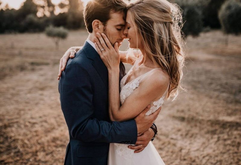 Un couple amoureux se serre dans les bras, entouré par la beauté naturelle des champs en Provence, évoquant une ambiance romantique et élégante. Ce moment capturé illustre parfaitement l'expertise de By Mademoiselle C en tant que wedding planner en Provence, Côte d'Azur et Corse. Avec une attention méticuleuse aux détails, chaque mariage est conçu comme un événement unique et sur mesure, idéal pour une grande célébration ou un rêve de mariage. Les paysages en toile de