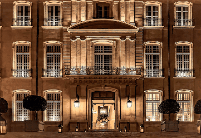 Une magnifique façade de bâtiment illuminée, idéale pour un mariage de luxe en Provence, Côte d'Azur et Corse. Cette propriété élégante sert de cadre pour une cérémonie grandiose, offrant des espaces exceptionnels pour un événement sur mesure. Avec ses jardins raffinés et son ambiance romantique, cet endroit est parfait pour célébrer un mariage de rêve. L'organisation bespoke de By Mademoiselle C garantit une expérience unique et mémorable dans ce domaine privé, où chaque détail est soigneusement pensé