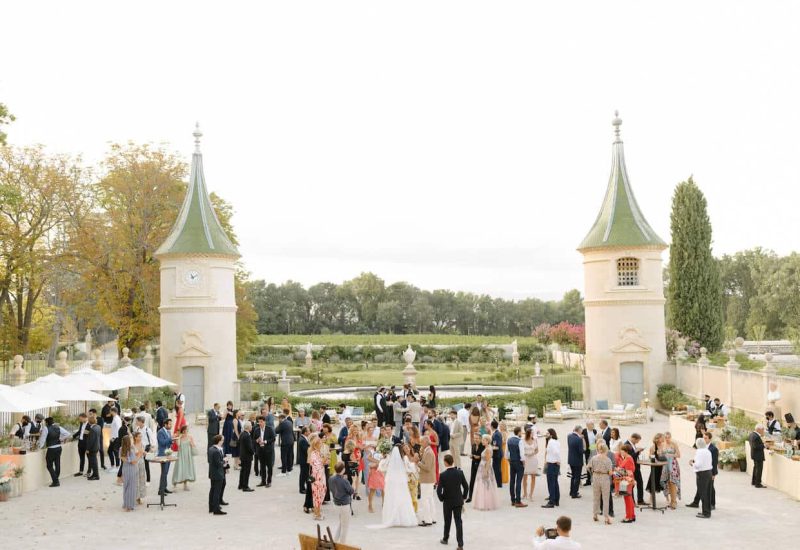 Une célébration grandiose dans un domaine privé en Provence, où l'élégance et le romantisme se rencontrent. Ce mariage sur mesure, orchestré par By Mademoiselle C, offre un cadre exceptionnel avec des invités profitant d'un jardin luxuriant et d'une vue sur les vignes. Une expérience de mariage de luxe pour une journée inoubliable.