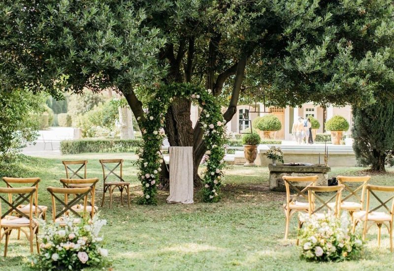 Célébrez votre rêve de mariage dans un cadre romantique et élégant avec 'By Mademoiselle C', planificateur de mariage de luxe en Provence, Côte d'Azur et Corse. Cette cérémonie grandiose se déroule sous un arbre majestueux, entourée de fleurs délicates et de chaises en bois, créant une atmosphère sophistiquée. Idéal pour un événement unique, ce domaine privé offre des lieux exceptionnels pour une célébration sur mesure. Transformez votre