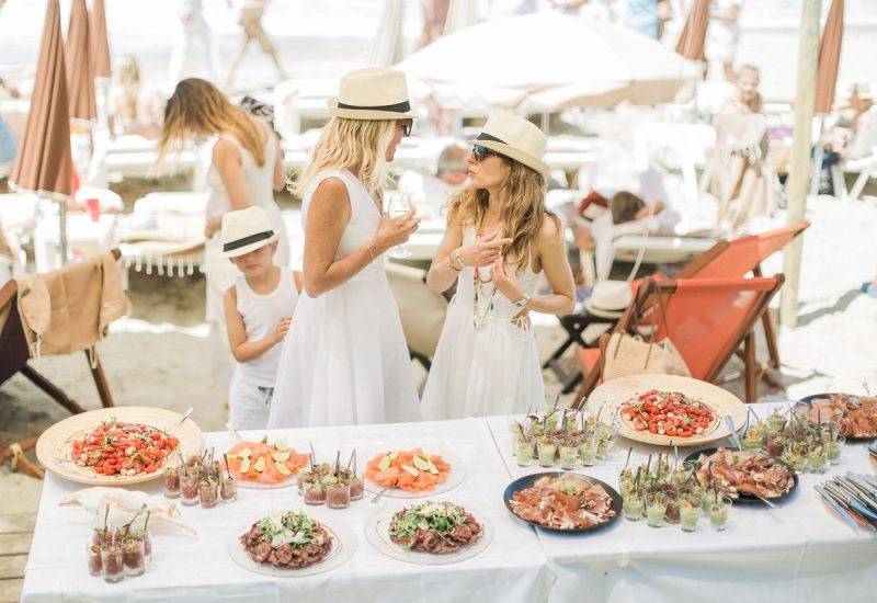 Une célébration de mariage romantique sur la plage, mettant en avant un service de traiteur de luxe avec des mets exquis, idéal pour une cérémonie sur mesure. L'atmosphère élégante et décontractée, entourée de sable et de mer, évoque une expérience unique pour un grand événement. 'By Mademoiselle C' excelle dans l'organisation de mariages exceptionnels en Provence, Côte d'Azur et en Corse, offrant des lieux privés et des célébrations grand