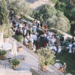 Une célébration grandiose dans un domaine privé en Provence, où des invités élégamment vêtus profitent d'une ambiance romantique et sophistiquée. Ce mariage sur mesure, organisé par By Mademoiselle C, met en valeur des espaces exceptionnels entourés de verdure luxuriante. La terrasse offre une vue imprenable sur les paysages pittoresques, créant un cadre parfait pour un événement unique. Avec des détails raffinés, cette cérémonie de luxe incarne le rêve d