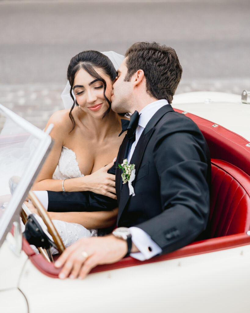 Un couple heureux dans une voiture vintage, célébrant leur mariage romantique en Provence. Cette image évoque l'élégance d'une cérémonie grandiose, soulignant l'expertise de By Mademoiselle C en tant que wedding planner de luxe. Parfait pour une célébration sur mesure dans un cadre exceptionnel, cette scène incarne le rêve d'un mariage unique et sophistiqué sur la Côte d'Azur.