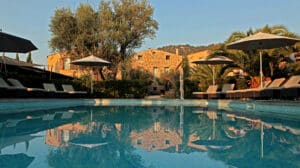 Une élégante piscine entourée de palmiers et de chaises longues, située dans un domaine privé en Provence, Côte d'Azur. Ce cadre romantique est parfait pour une cérémonie de mariage de luxe, offrant une atmosphère sophistiquée pour un événement sur mesure. Avec des vues imprenables sur les montagnes et un jardin luxuriant, chaque détail de cette célébration grandiose est soigneusement orchestré par By Mademoiselle C, spécialiste des mariages uniques et des célébr