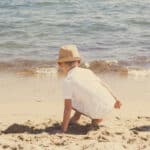 Un enfant s'amusant sur une plage de sable fin, symbolisant l'atmosphère joyeuse d'une cérémonie romantique. Cette scène évoque un mariage de luxe en Provence, Côte d'Azur et Corse, où chaque détail est soigneusement organisé pour créer un événement unique. Les eaux scintillantes et l'environnement naturel renforcent l'idée d'une célébration grandiose dans un cadre exceptionnel. En tant que planificateur de mariage sur mesure, By Mademoiselle C