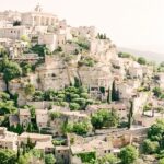 Un paysage pittoresque de Gordes, en Provence, évoquant une atmosphère romantique et élégante, parfaite pour une cérémonie de mariage de luxe. Ce cadre unique, avec ses maisons en pierre et ses jardins luxuriants, est idéal pour une organisation sur mesure d'un événement grandiose. En tant que planificateur de mariage en Provence, Côte d'Azur et Corse, By Mademoiselle C crée des célébrations exceptionnelles dans des lieux privés, transformant chaque rêve de