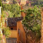 Un charmant chemin sinueux bordé de maisons provençales colorées, idéal pour une cérémonie de mariage romantique. Ce paysage pittoresque, entouré de verdure luxuriante et de collines, évoque l'élégance d'une célébration grandiose. En tant que planificateur de mariage de luxe en Provence, Côte d'Azur et Corse, By Mademoiselle C crée des événements sur mesure dans des lieux exceptionnels comme ce domaine privé. Chaque détail