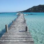 Pont en bois menant à une eau cristalline, idéal pour un mariage romantique en Corse. Ce cadre enchanteur, avec ses paysages côtiers, évoque une célébration grandiose et unique. By Mademoiselle C, wedding planner en Provence, Côte d'Azur et Corse, crée des événements sur mesure dans des lieux exceptionnels, parfaits pour un grand mariage ou une cérémonie intime. Profitez d'une atmosphère élégante et sophistiquée, où chaque détail