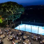 Un élégant dîner en plein air dans un domaine privé, mettant en valeur un cadre romantique sous les lumières scintillantes du soir. Ce mariage sur mesure, orchestré par By Mademoiselle C, est une véritable célébration de luxe, où chaque détail contribue à une expérience inoubliable. La piscine illuminée et les tables magnifiquement dressées témoignent d'une organisation exceptionnelle pour un événement unique en Provence, Côte d'Azur et Corse. Ce grand moment de bonheur, dans