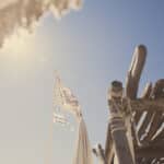 Drapeaux flottant au-dessus d'une élégante structure en bois sur une plage ensoleillée, évoquant une ambiance romantique et sophistiquée, idéale pour un grand mariage. Cette scène capture l'essence d'un événement sur mesure, parfait pour une célébration de luxe en Provence, Côte d'Azur et Corse. Avec des paysages enchanteurs en toile de fond, 'By Mademoiselle C' transforme chaque moment en un rêve inoubliable, offrant des lieux exception